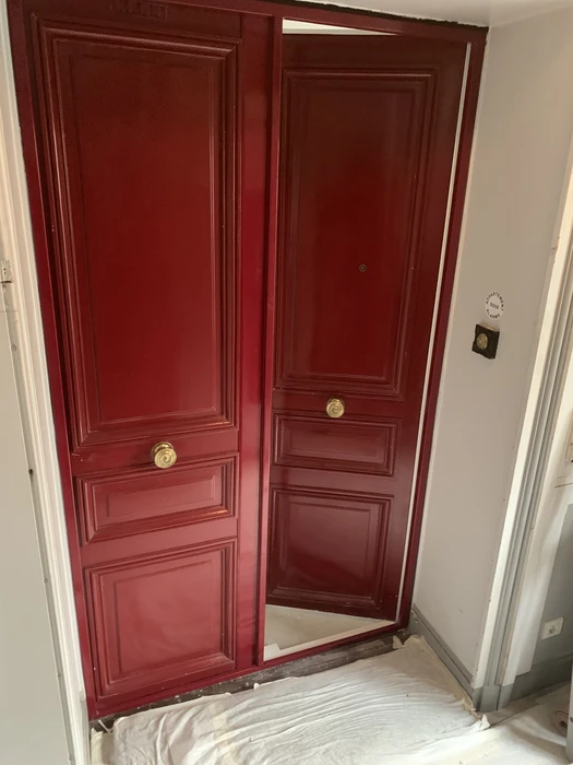 Intérieur d'un vestibule avec deux portes battantes de style classique peint en rouge bordeaux éclatant