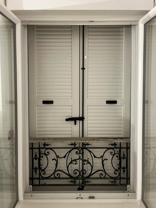 Fenêtre française ouverte donnant sur un balcon intérieur