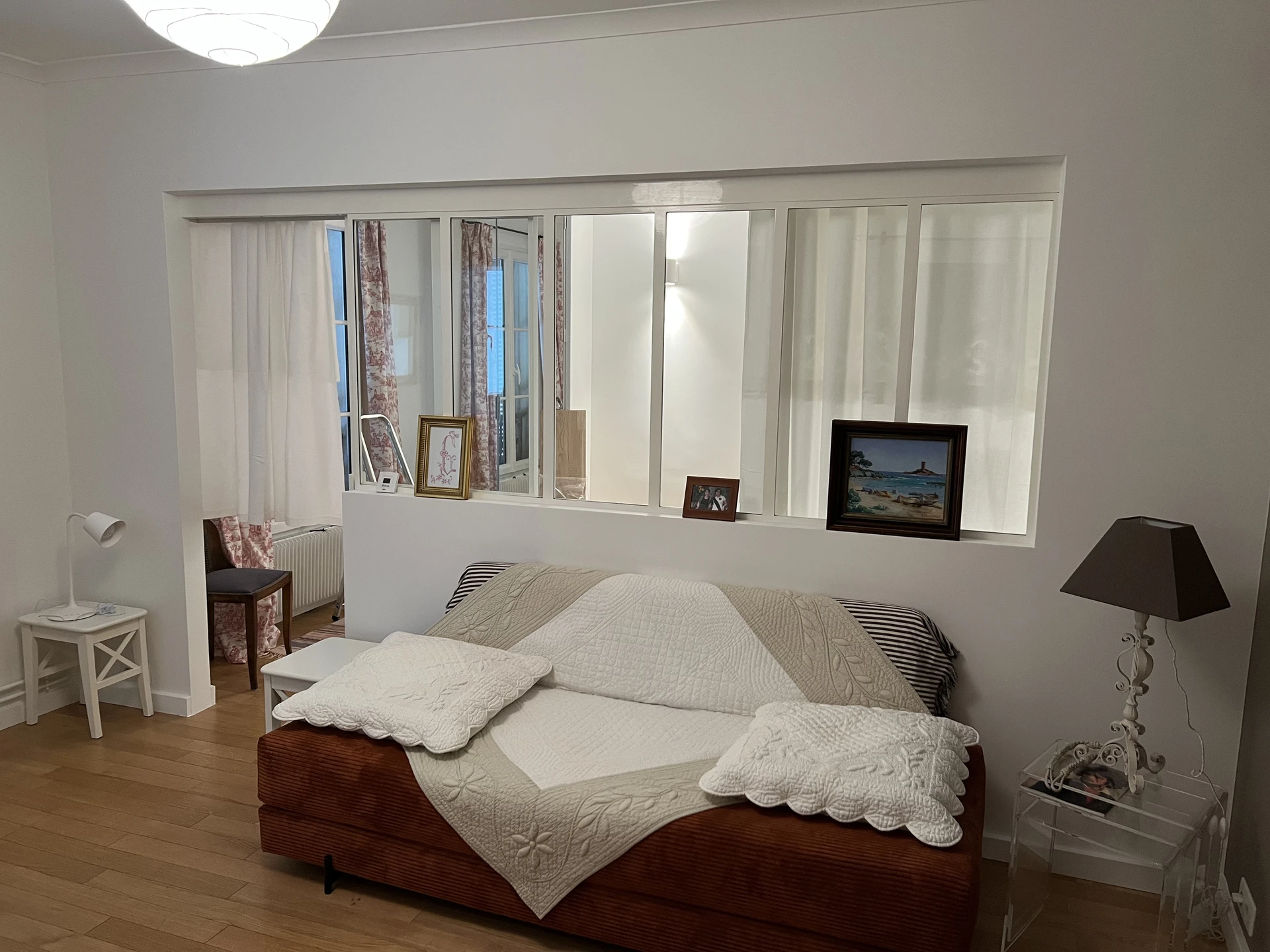 Chambre moderne avec lit recouvert d'une couette et d'oreillers blancs crème