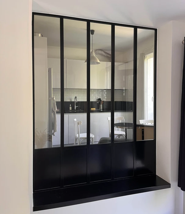 Intérieur d'une pièce en construction avec une baie vitrée donnant sur un chantier