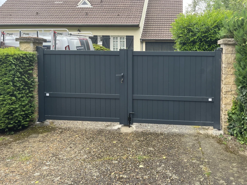 Portail d'entrée résidentiel moderne en aluminium anthracite, composé de deux vantaux battants avec lames verticales