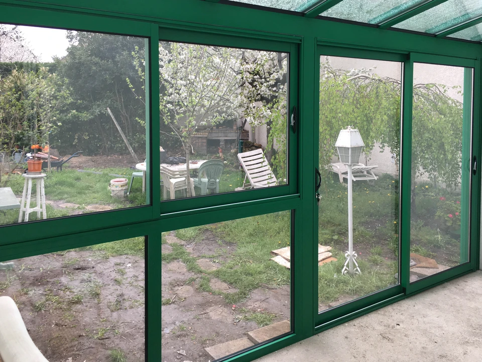 Véranda contemporaine en aluminium blanc avec toiture vitrée plate et structure modulaire
